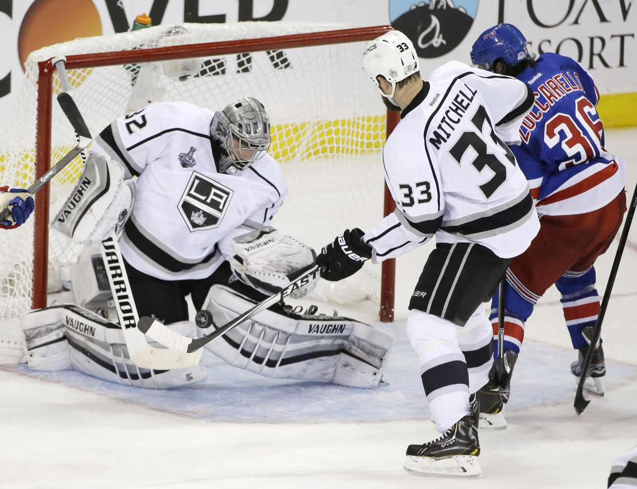 Los Angeles Kings goalie Jonathan Quick (32) blocks a shot by New York Rangers right wing Mats Zuccarello (36) as Kings defenseman Willie Mitchell (33) helps defend in the second period during Game 3 of the NHL hockey Stanley Cup Final, Monday, June 9, 2014, in New York.