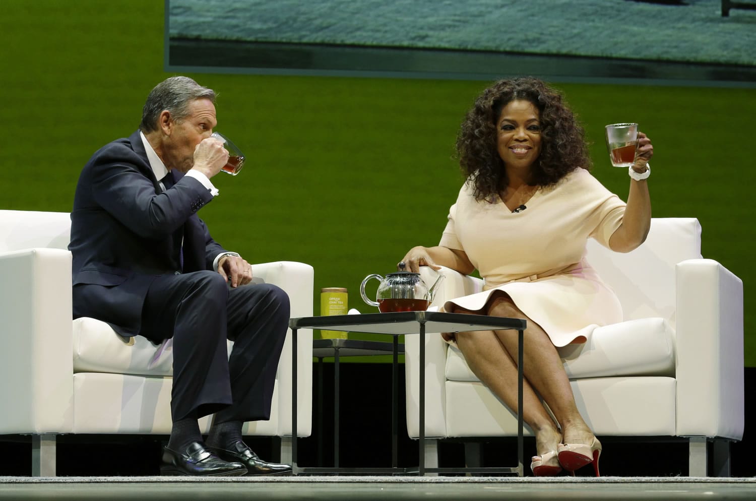 Howard Schultz, left, chairman and CEO of Starbucks Coffee Company, drinks tea with Oprah Winfrey on  Wednesday at Starbucks' annual shareholders meeting in Seattle.