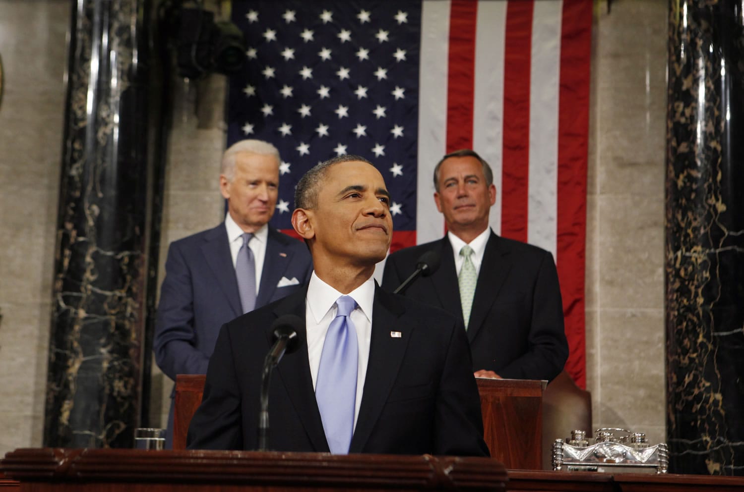 President Barack Obama smiles as he arrives to deliver the State of Union address before a joint session of Congress in the House chamber Tuesda in Washington, as Vice President Joe Biden, and House Speaker John Boehner of Ohio, watch.