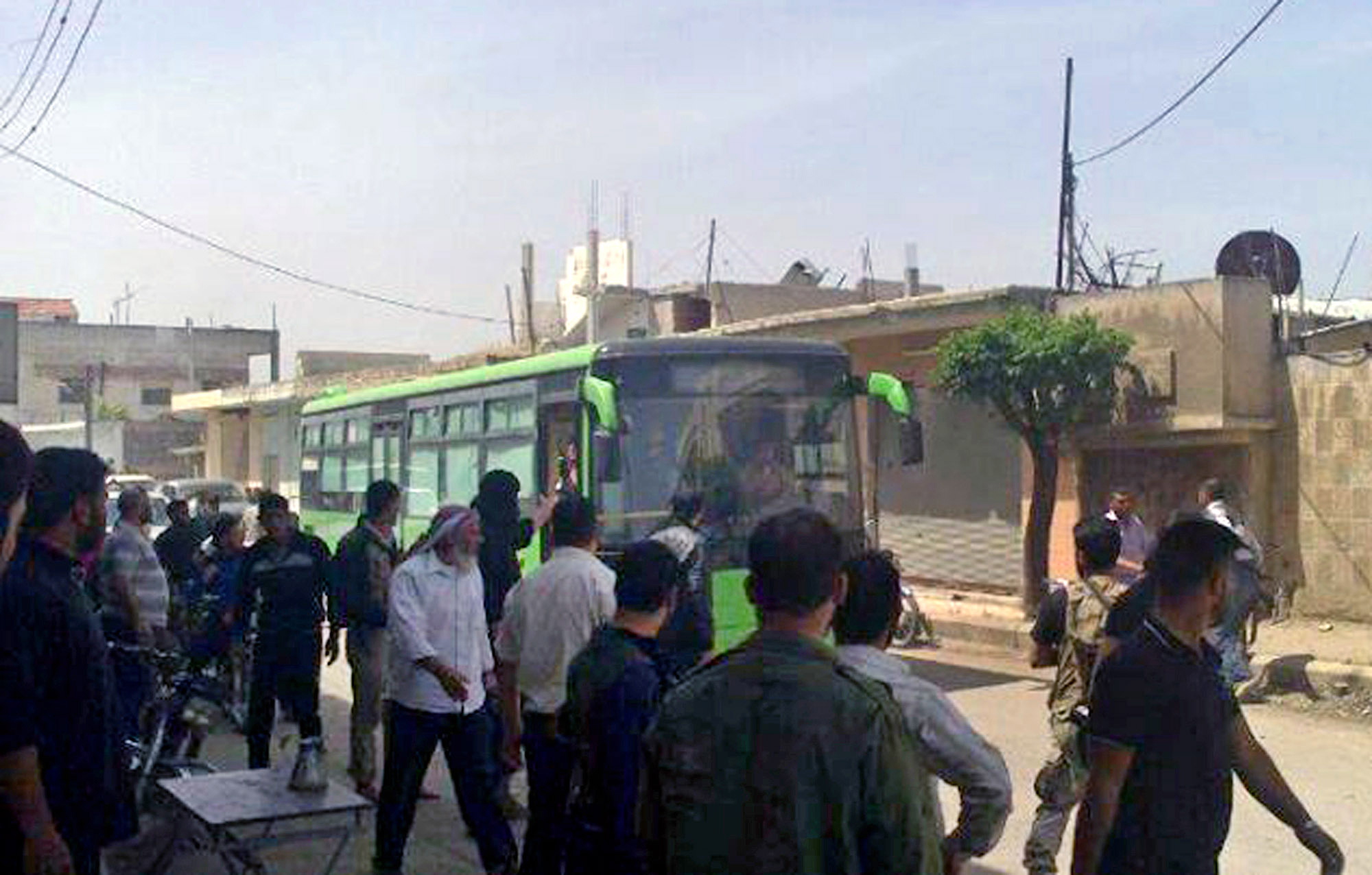 Free Syrian Army fighters board a bus leaving Homs, Syria, earlier this month.