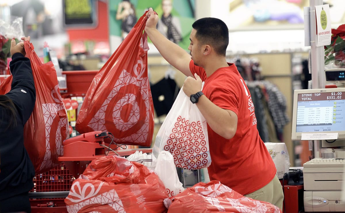 A Target employee hands bags to a customer at the register at a Target store in Colma, Calif.