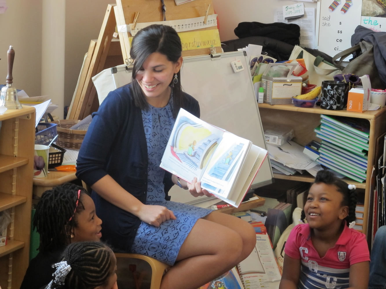 Student teacher Franchesca Moreno, 21, reads to  Andreanna Thomas, 6, right, and Alana Cawthon, upper left, at Bennett Park Montessori School in Buffalo, N.Y.