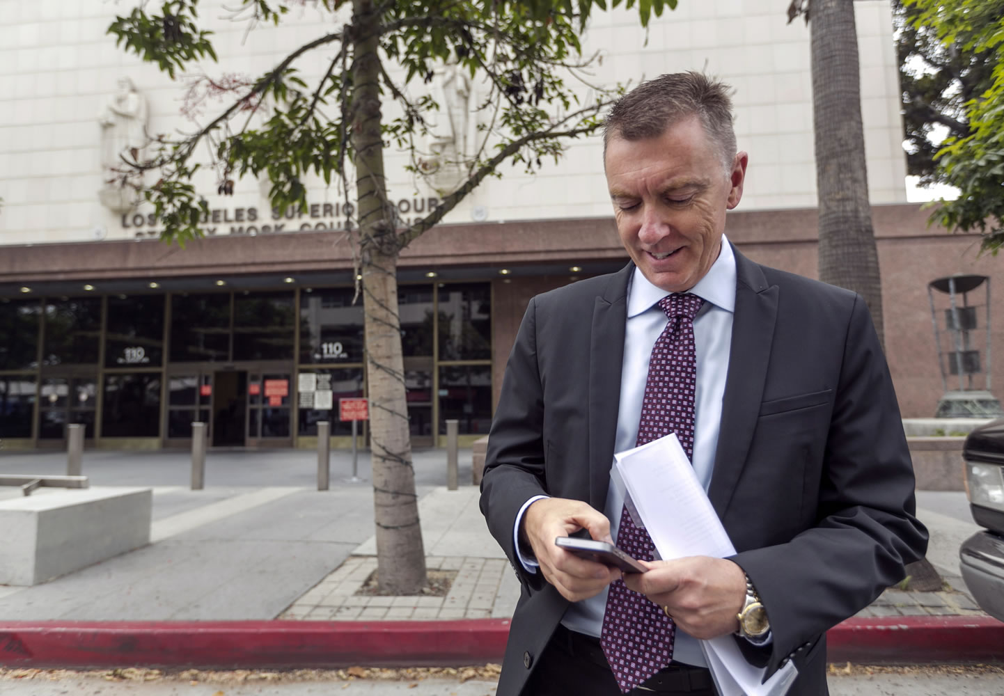 Los Angeles Unified School District Superintendent John Deasy checks his phone outside the Stanley Mosk Courthouse, before the verdict in the Vergara v.