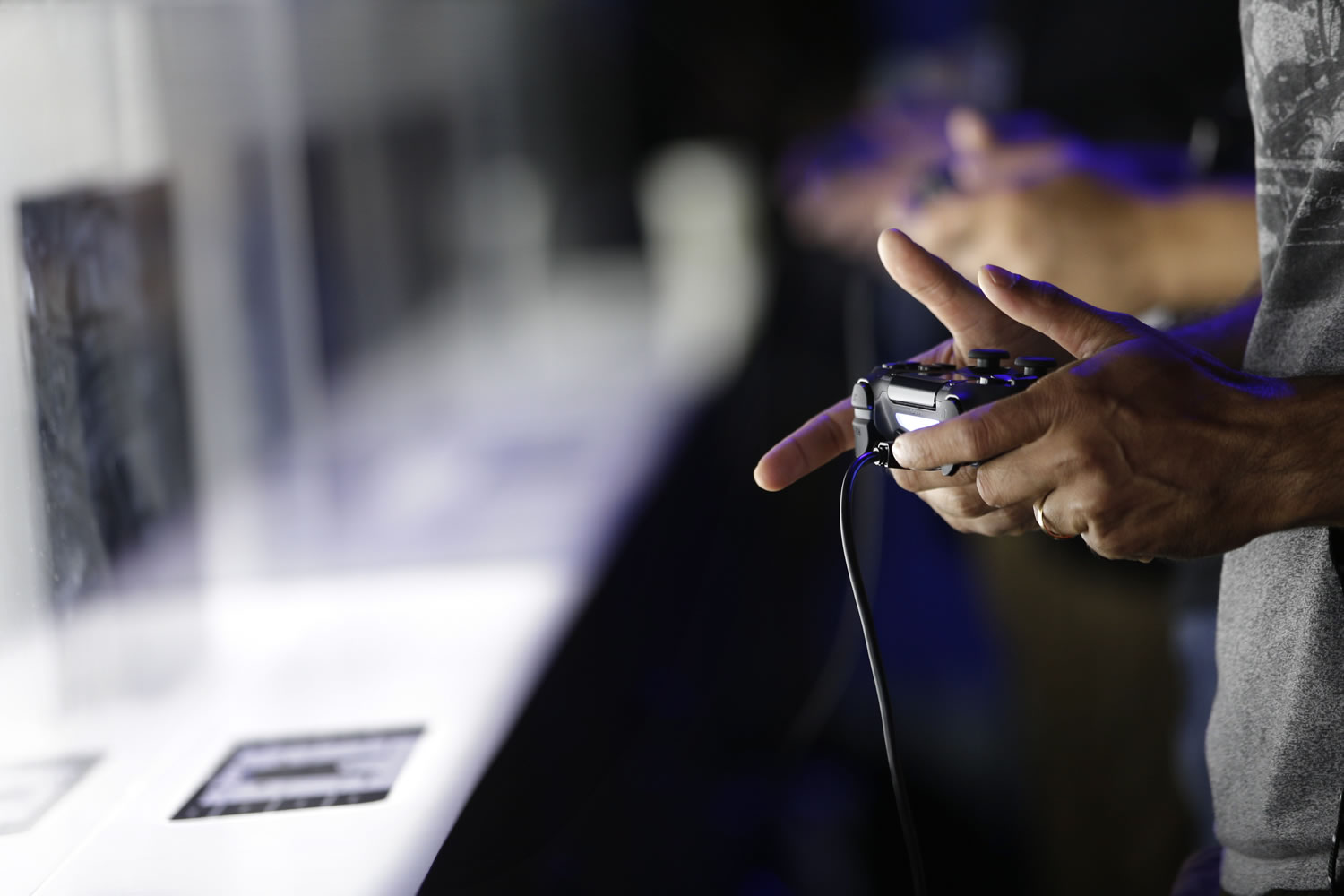 Attendees play video games on the PlayStation 4 at the Sony booth during the Electronic Entertainment Expo in Los Angeles.