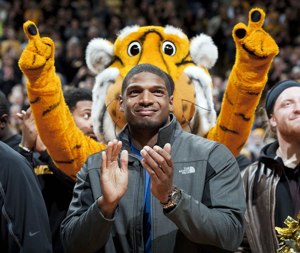 Missouri's All-American defensive end Michael Sam claps during the Cotton Bowl trophy presentation at halftime of an NCAA college basketball game between Missouri and Tennessee, Saturday, Feb. 15, 2014, in Columbia, Mo. Sam came out to the entire country Sunday, Feb. 9, and could become the first openly gay player in the NFL. (AP Photo/L.G.