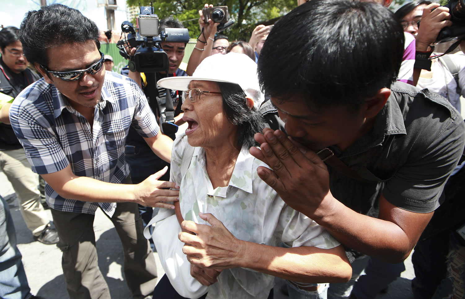 A protester, center, is arrested by plainclothes Thai police officers after staging an anti-coup demonstration in Bangkok, Thailand Sunday, June 1, 2014. An anti-coup activist in Thailand called Friday for a weekend rally to defy the military government's ban on demonstrations, urging those opposed to the takeover to wear masks and be ready for cat-and-mouse chases with soldiers in the capital.