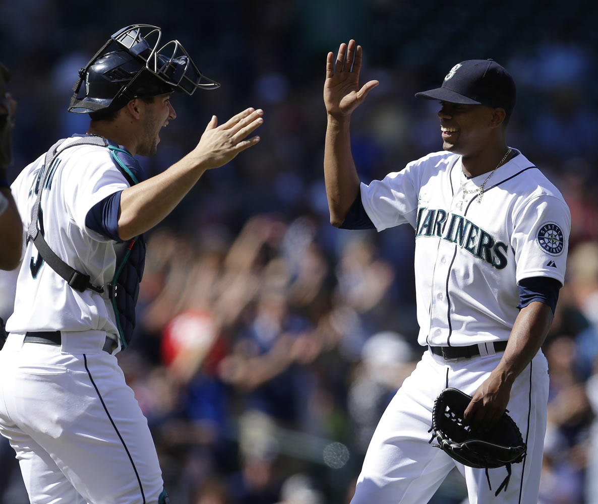 Seattle Mariners starting pitcher Roenis Elias, right, is greeted by catcher Mike Zunino after throwing a complete shutout baseball game against the Detroit Tigers, Sunday, June 1, 2014, in Seattle. The Mariners won 4-0. (AP Photo/Ted S.