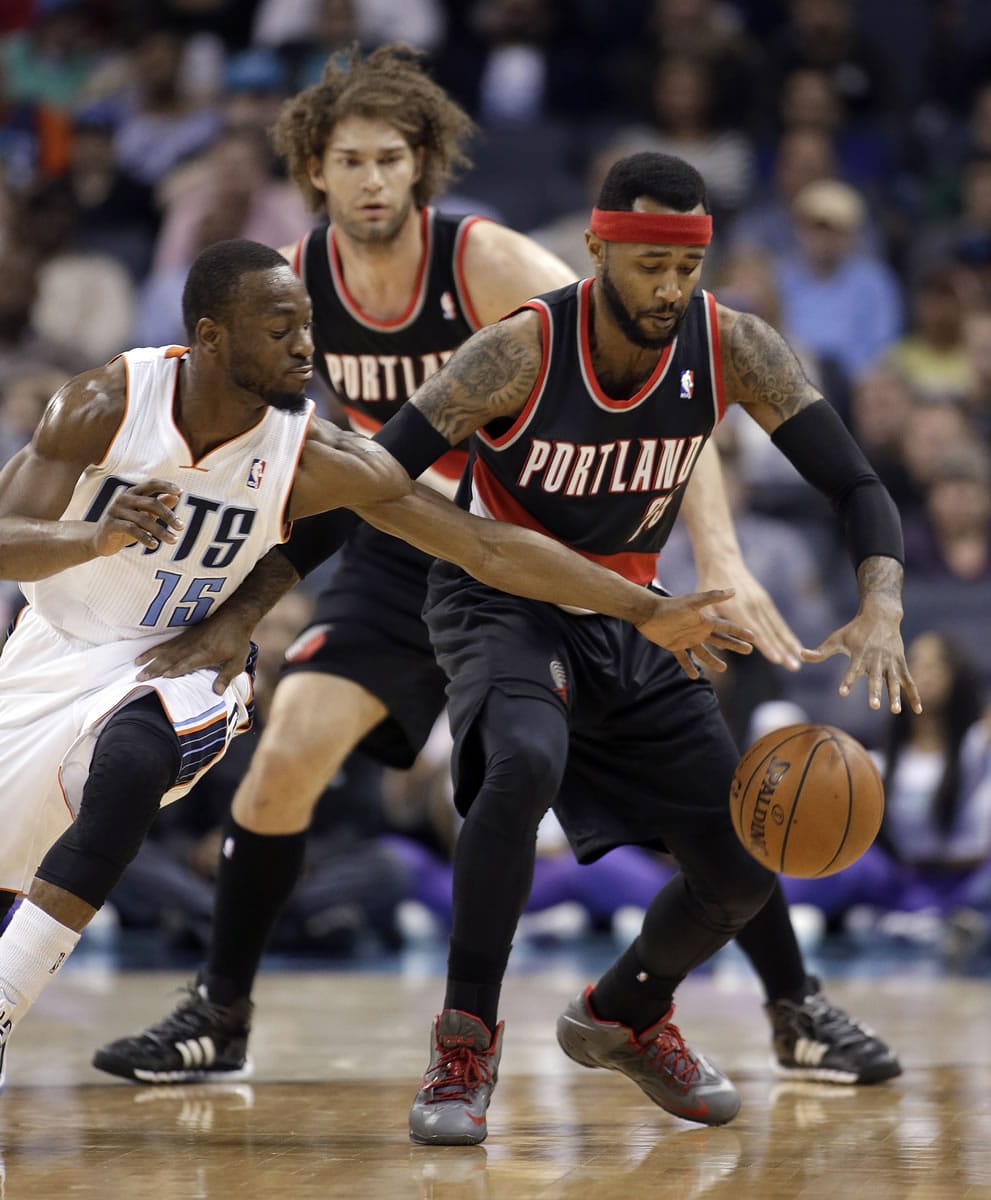 Charlotte Bobcats' Kemba Walker, left stretches to make a steal from Portland Trail Blazers' Mo Williams, right as Portland Trail Blazers' Robin Lopez watches from behind during the first half of an NBA basketball game in Charlotte, N.C., Saturday, March 22, 2014.