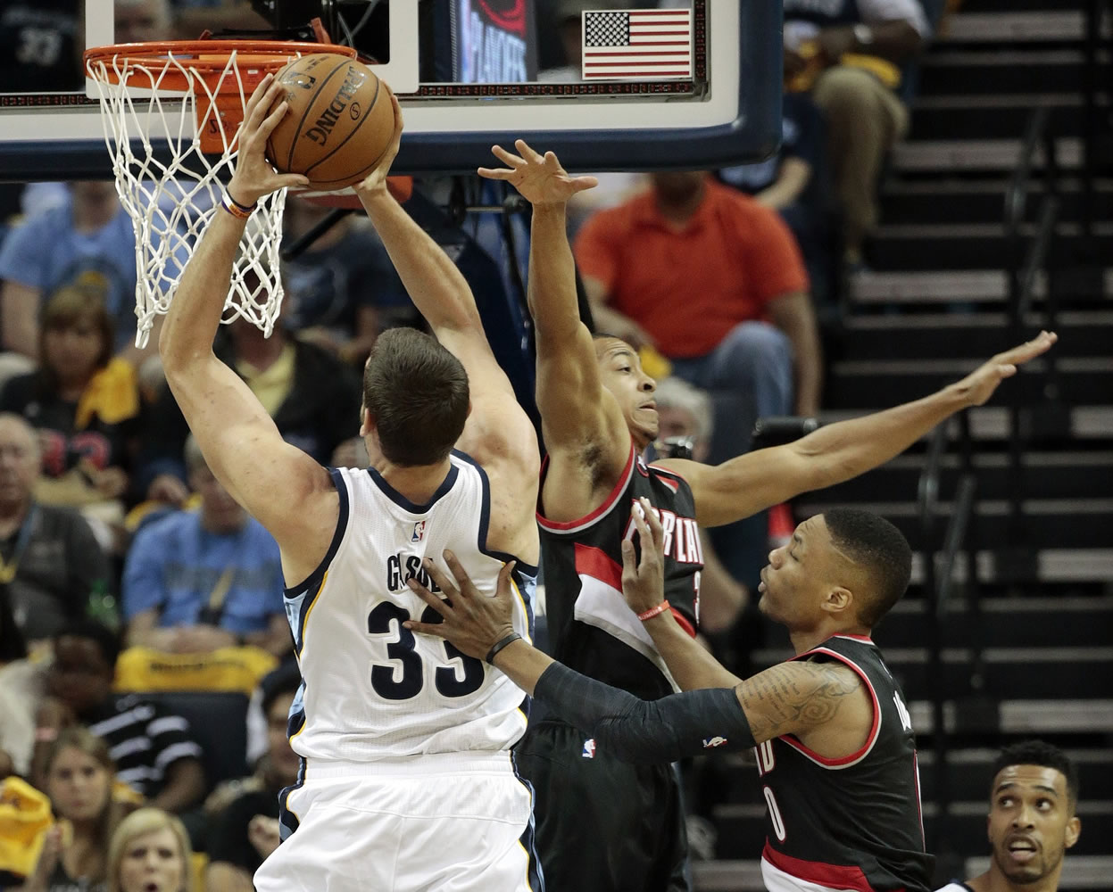 Memphis center Marc Gasol (33) shoots past Portland defenders C.J. McCollum, center, and Damian Lillard, right, in the first half of Game 1 on Sunday, April 19, 2015, in Memphis, Tenn.