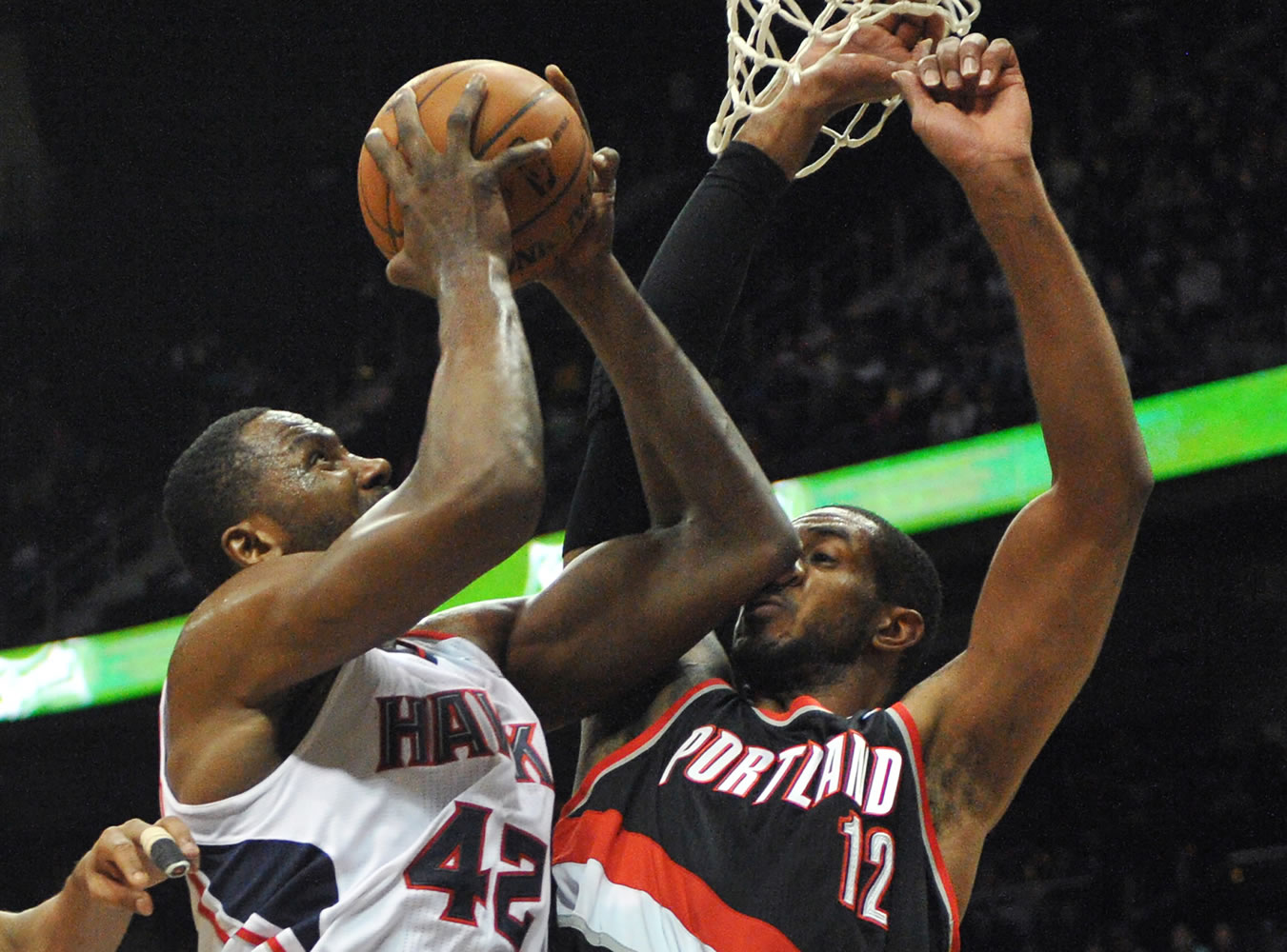 Portland Trail Blazers ' LaMarcus Aldridge (12) gets an elbow to the nose as Atlanta Hawks' Elton Brand (42) shoots in the first half of their NBA basketball game Thursday, March 27, 2014, in Atlanta.