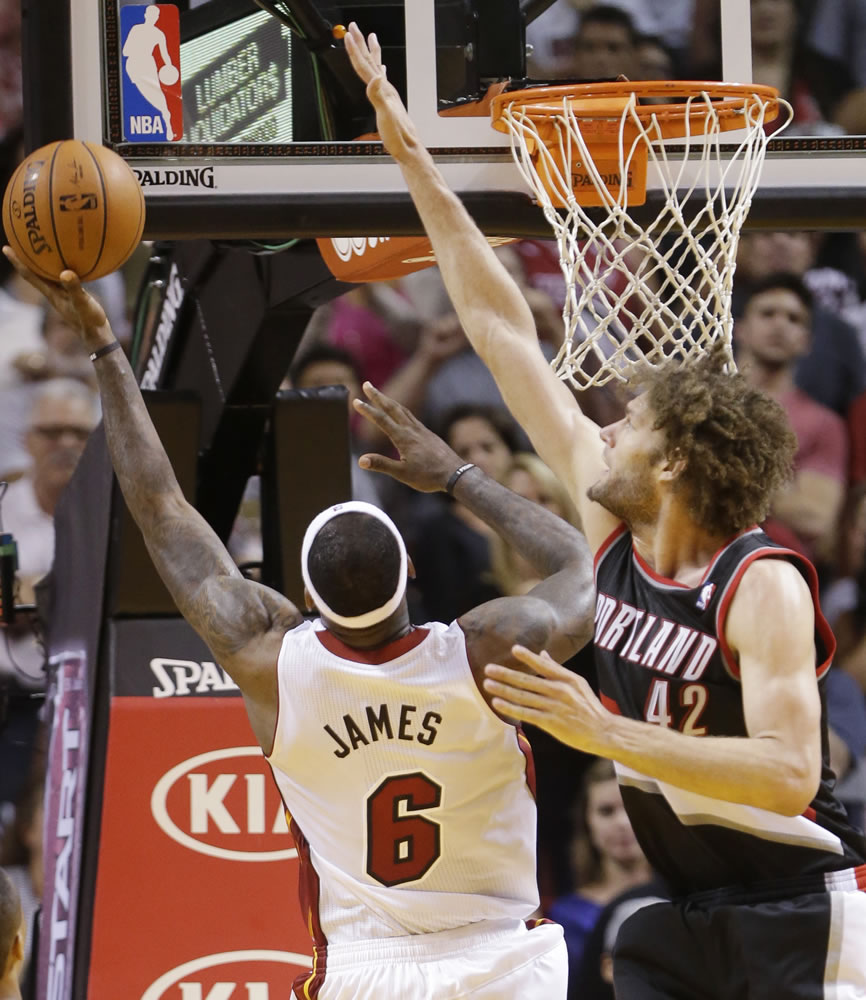 Miami Heat forward LeBron James (6) makes a shot against Portland Trail Blazers center Robin Lopez (42) in the final seconds of the second half of an NBA basketball game to defeat the Trail Blazers 93-91, Monday, March 24, 2014 in Miami.