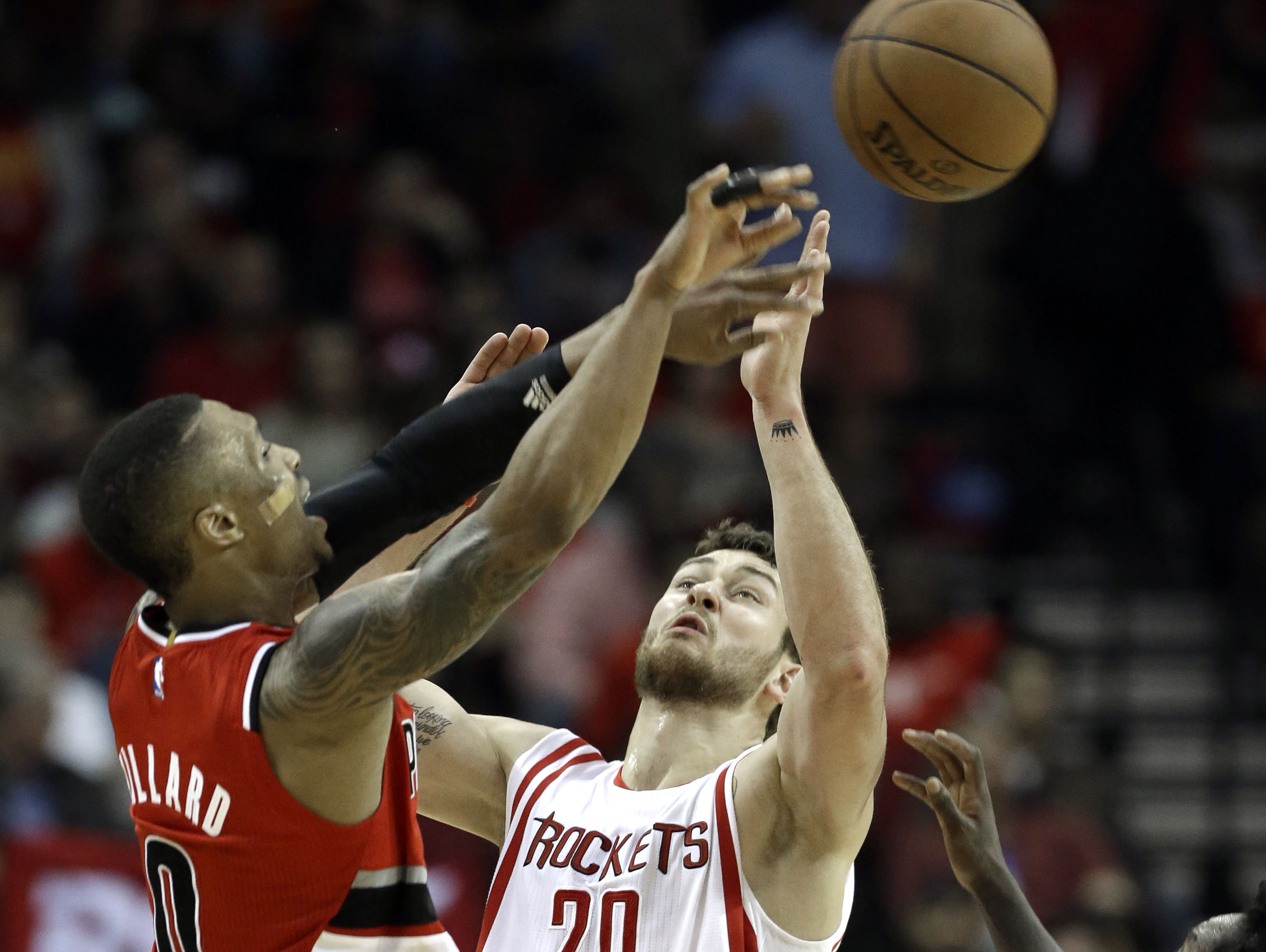 Portland Trail Blazers' Damian Lillard (0) shoots over Houston Rockets' Donatas Motiejunas (20) in the second half Monday, Dec. 22, 2014, in Houston. The Rockets won 110-95.
