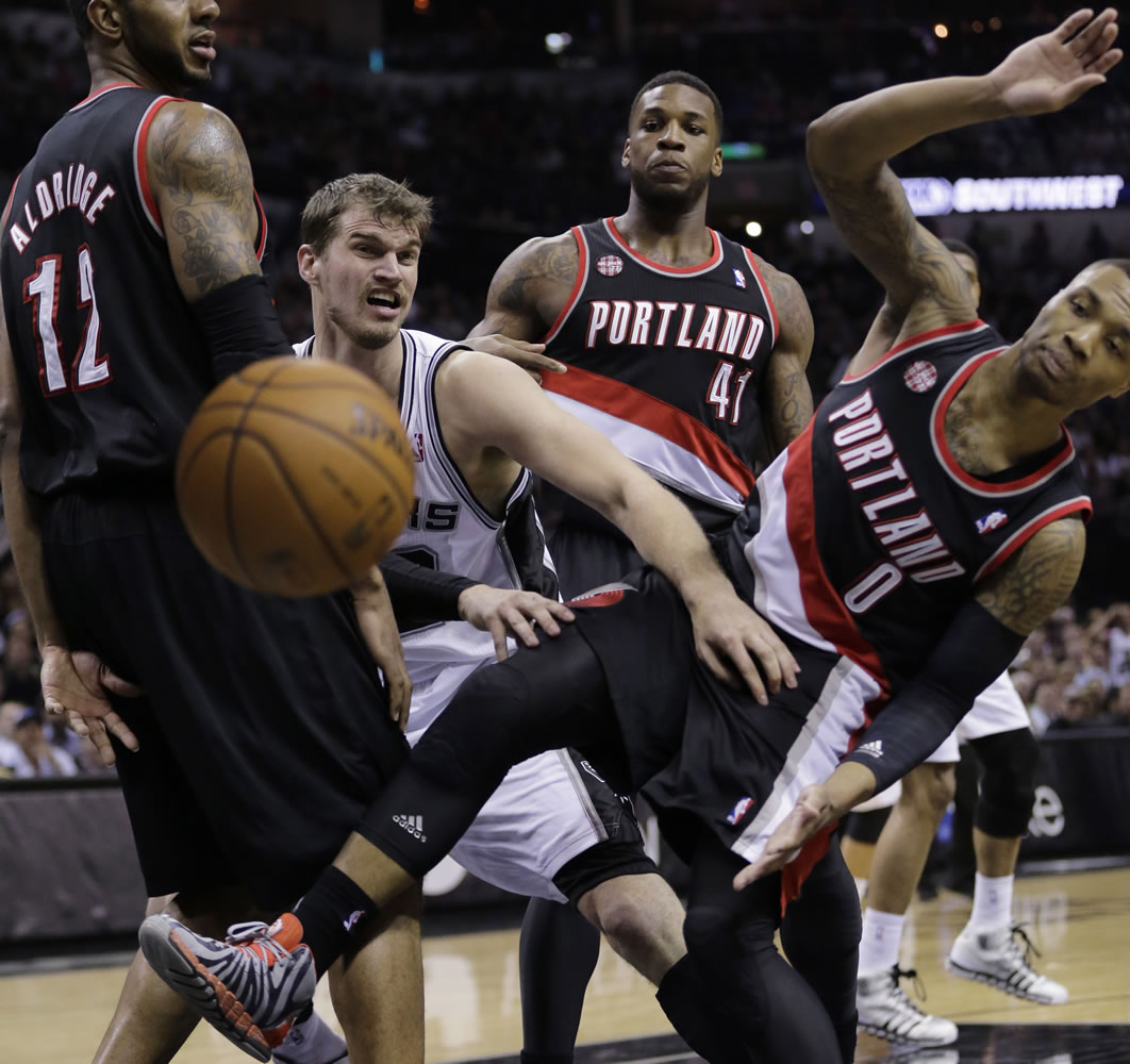 San Antonio Spurs' Tiago Splitter, center, of Brazil, battles Portland Trail Blazers' LaMarcus Aldridge (12), Thomas Robinson (41) and Damian Lillard (0) for a loose ball during the first half of Game 2 of a Western Conference semifinal NBA basketball playoff series, Thursday, May 8, 2014, in San Antonio.