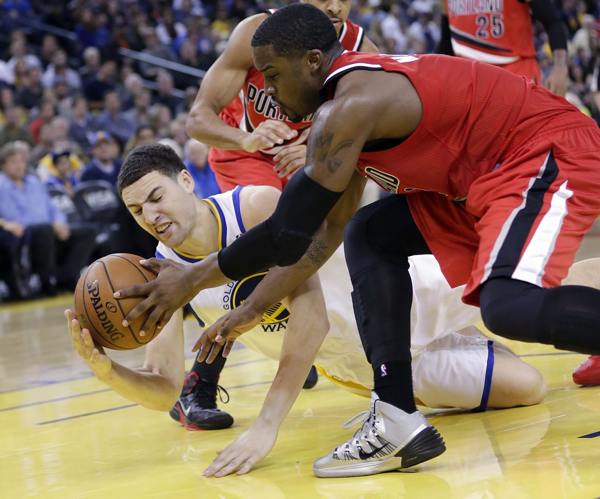 Golden State Warriors' Klay Thompson, left, fights for a loose ball against Portland Trail Blazers' Wesley Matthews, right, during the second half of an NBA basketball game on Sunday, Jan. 26, 2014, in Oakland, Calif. Golden State won 103-88.