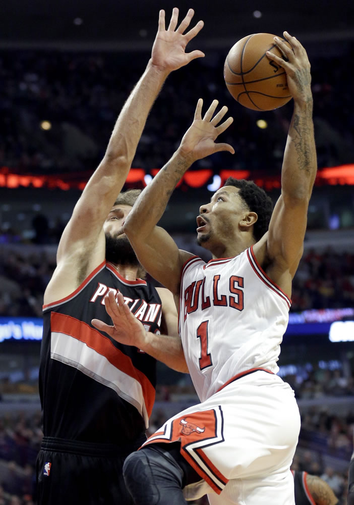 Chicago Bulls guard Derrick Rose (1) drives to the basket against Portland Trail Blazers center Robin Lopez (42) during the second half in Chicago on Friday, Dec. 12, 2014. The Bulls won 115-106. (AP Photo/Nam Y.