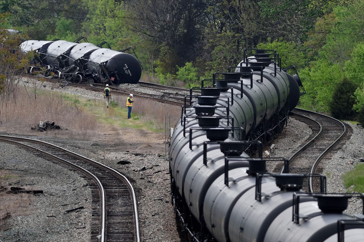 Workers inspect the scene April 30 after several CSX tanker cars carrying crude oil derailed and caught fire along the James River in Lynchburg, Va.
