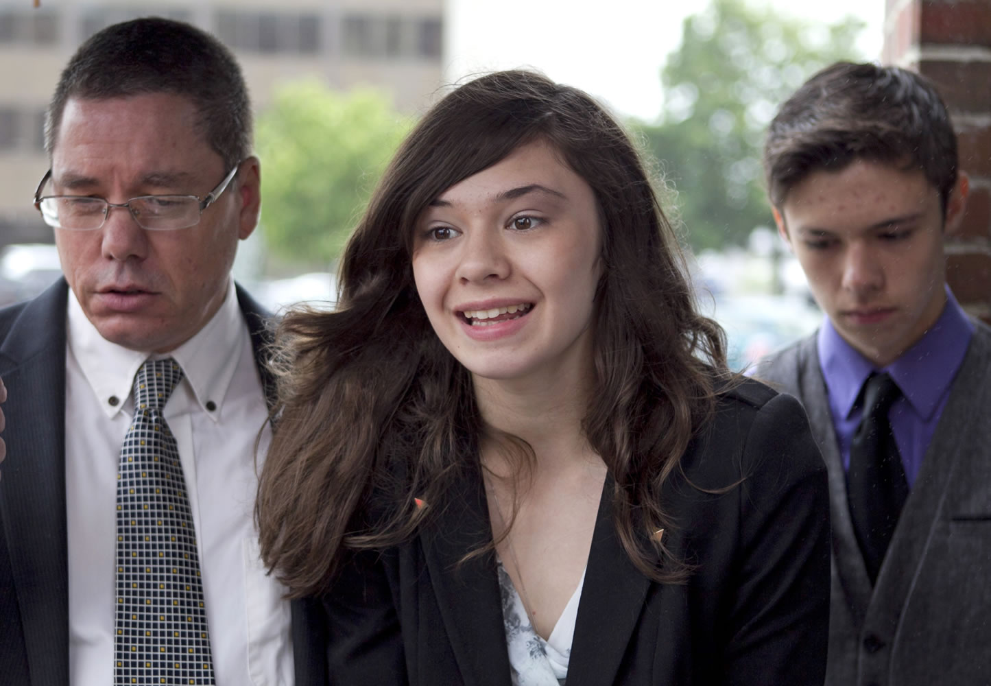 Transgender student Nicole Maines, center, with her father, Wayne Maines, left, and brother, Jonas, speaks to reporters outside the Penobscot Judicial Center in Bangor, Maine, on June 12.