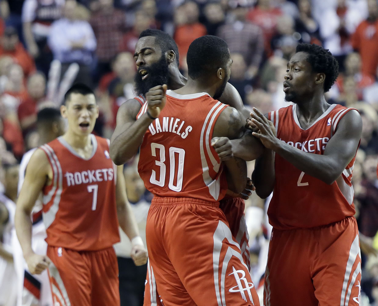 Houston Rockets guard Troy Daniels (30) celebrates with teammates James Harden, left, and Patrick Beverley after sinking a three point shot in overtime to take the lead during Game 3 Friday. The Rockets won 121-116.