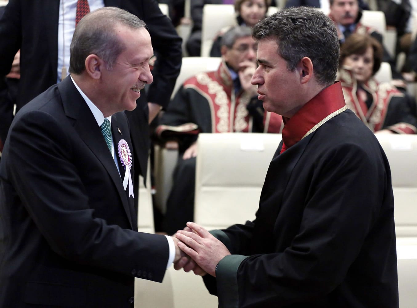 Turkish Prime Minister Recep Tayyip Erdogan, left, and Professor Metin Feyzioglu, chairman of of Turkey's Bar Associations, shake hands before a meeting in Ankara, Turkey, on Saturday, Erdogan interrupted Feyzioglu's critical speech and shouted at him before walking out the meeting: &quot; You are being rude!&quot;