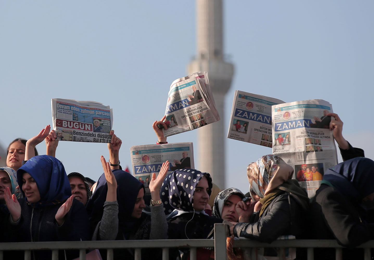 Women hold opposition newspapers as people gather Sunday outside the Justice Palace in Istanbul, Turkey, to protest against the latest detentions in Turkey.