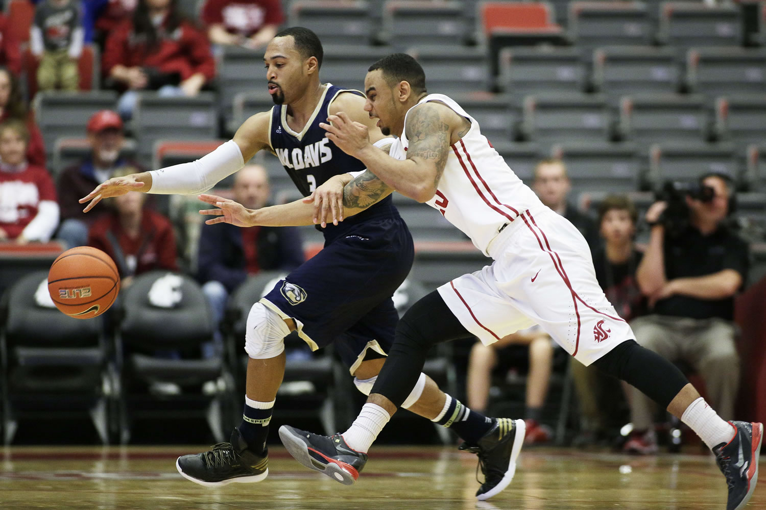 UC Davis' Corey Hawkins (3) and Washington State's DaVonte Lacy reach for a loose ball during the first half Sunday in Pullman.