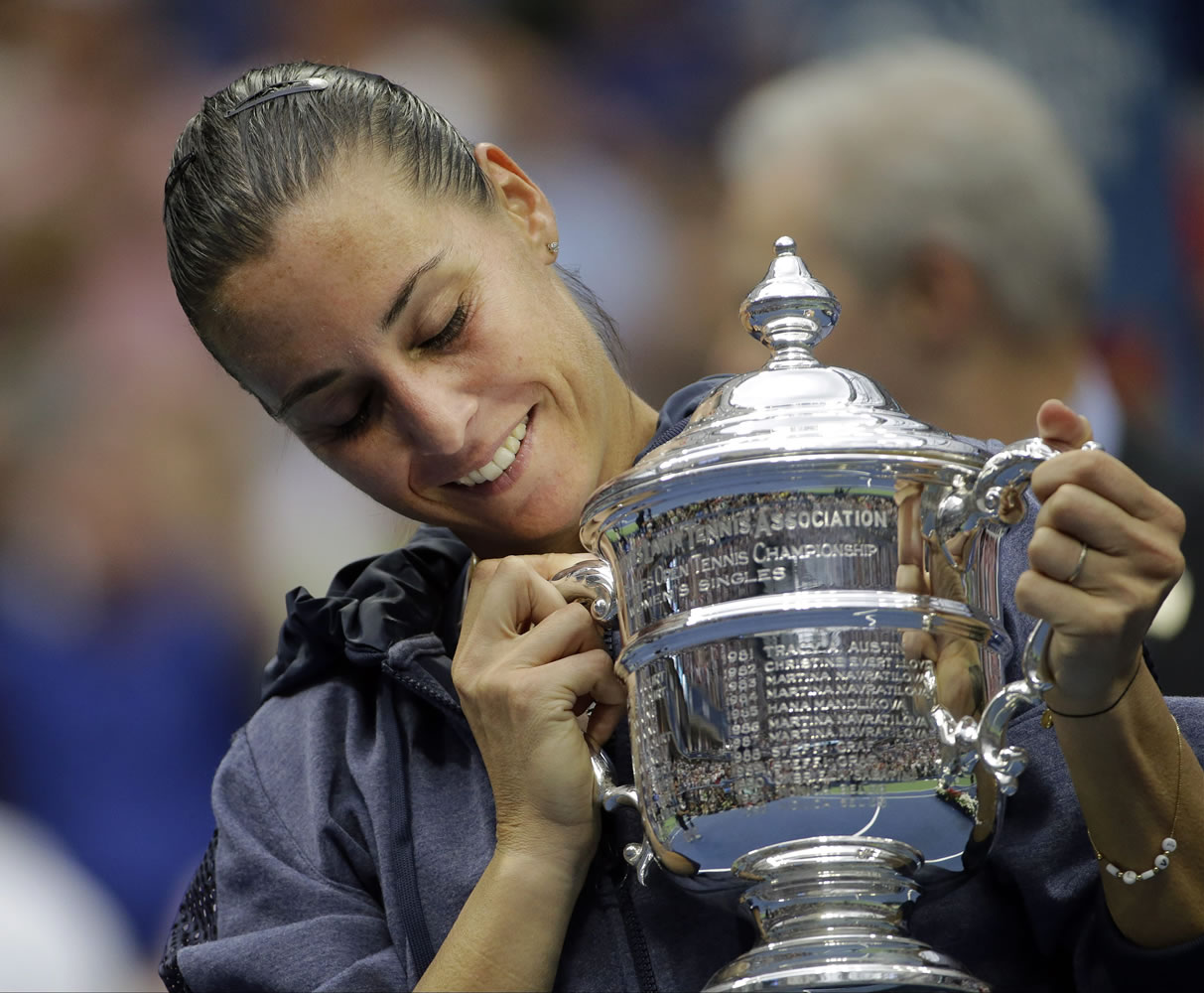 Flavia Pennetta, of Italy, holds up the championship trophy after beating Roberta Vinci, of Italy, in the women's championship match of the U.S. Open tennis tournament, Saturday, Sept. 12, 2015, in New York.