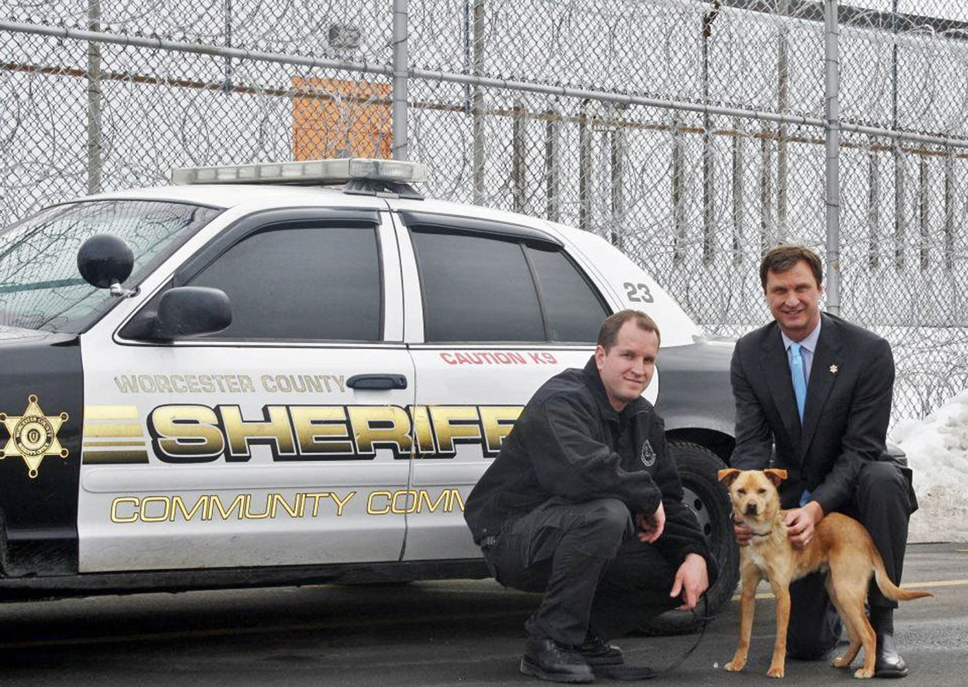 Lt. Thomas Chabot, from left, Sheriff Lew Evangelidis and the department's service dog Nikita, at the Worcester County Jail & House of Correction in West Boylston, Mass. Nikita, the mutt from a Massachusetts animal shelter who got a new life as a K-9 drug-detection dog, stars in an upcoming episode of a new PBS series called "Shelter Me: Partners for Life." The Worcester County sheriff's department in central Massachusetts turned to the shelter for help when there wasn't enough money in the budget to replace its retiring tracking dogs.