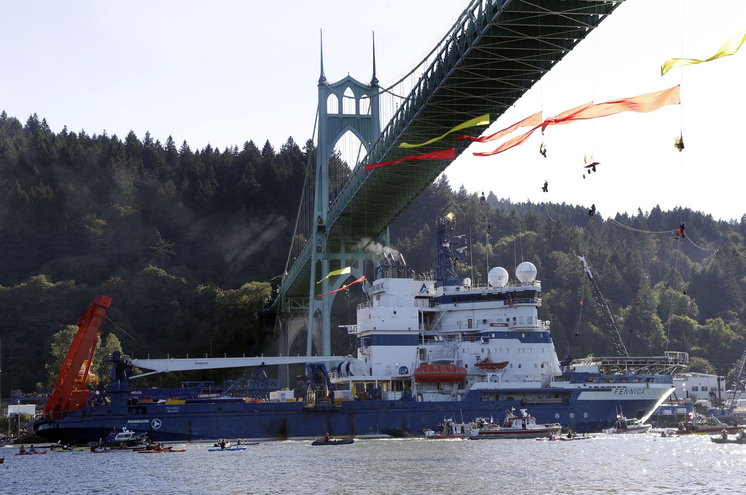 The Royal Dutch Shell PLC icebreaker Fennica heads up the Willamette River in July in Portland as protesters hang from the St. Johns Bridge on its way to Alaska. Royal Dutch Shell will cease exploration in Arctic waters off Alaska&#039;s coast following disappointing results from an exploratory well.