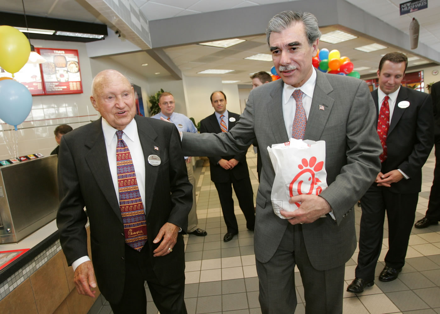 U.S. Secretary of Commerce Carlos Guiterrez, right, leaves with a lunch bag as Chick-fil-A founder S. Truett Cathy, left, walks him out July 25, 2006 after a meeting with Georgia business leaders to discuss immigration reform at Chick-fil-A in Atlanta.
