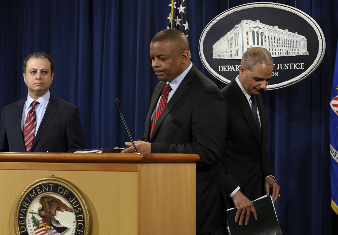 Attorney General Eric Holder, right, changes places with Transportation Secretary Anthony Foxx, center, during a news conference at the Justice Department in Washington on Wednesday.