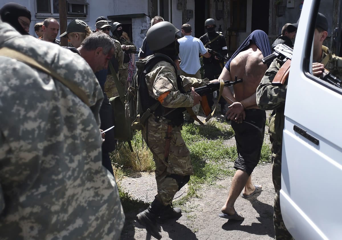 Ukrainian troops from battalion Azov on Friday escort to a bus men detained at a site of battle with pro-Russian fighters in Mariupol, eastern Ukraine.