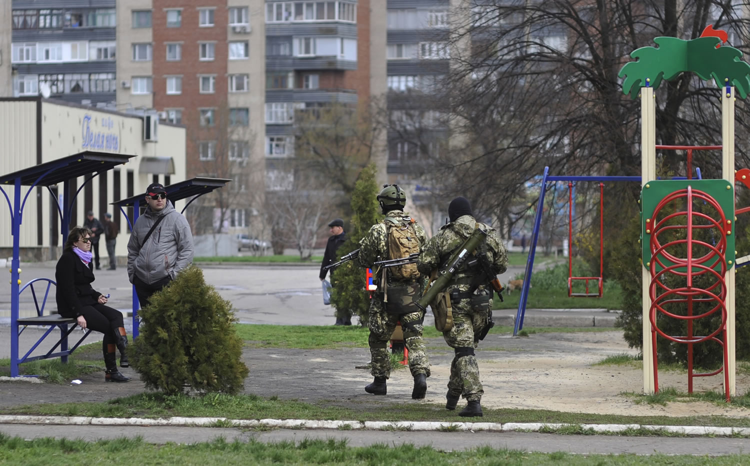Armed pro-Russian activists walk through a children's playground near to the seized Ukrainian regional administration building in the eastern Ukrainian town of Slovyansk, Ukraine, on Monday.