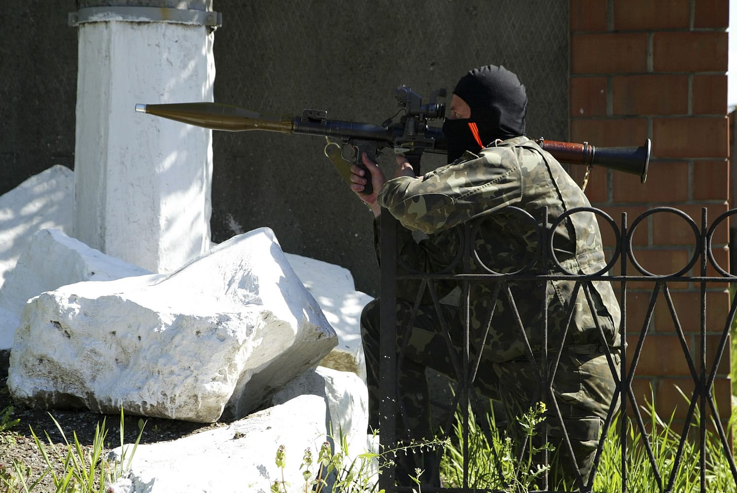 A pro-Russian militant aims his weapon as a group of gunmen try to block a military base of Ukrainian riot police in Donetsk, Ukraine, on Tuesday.