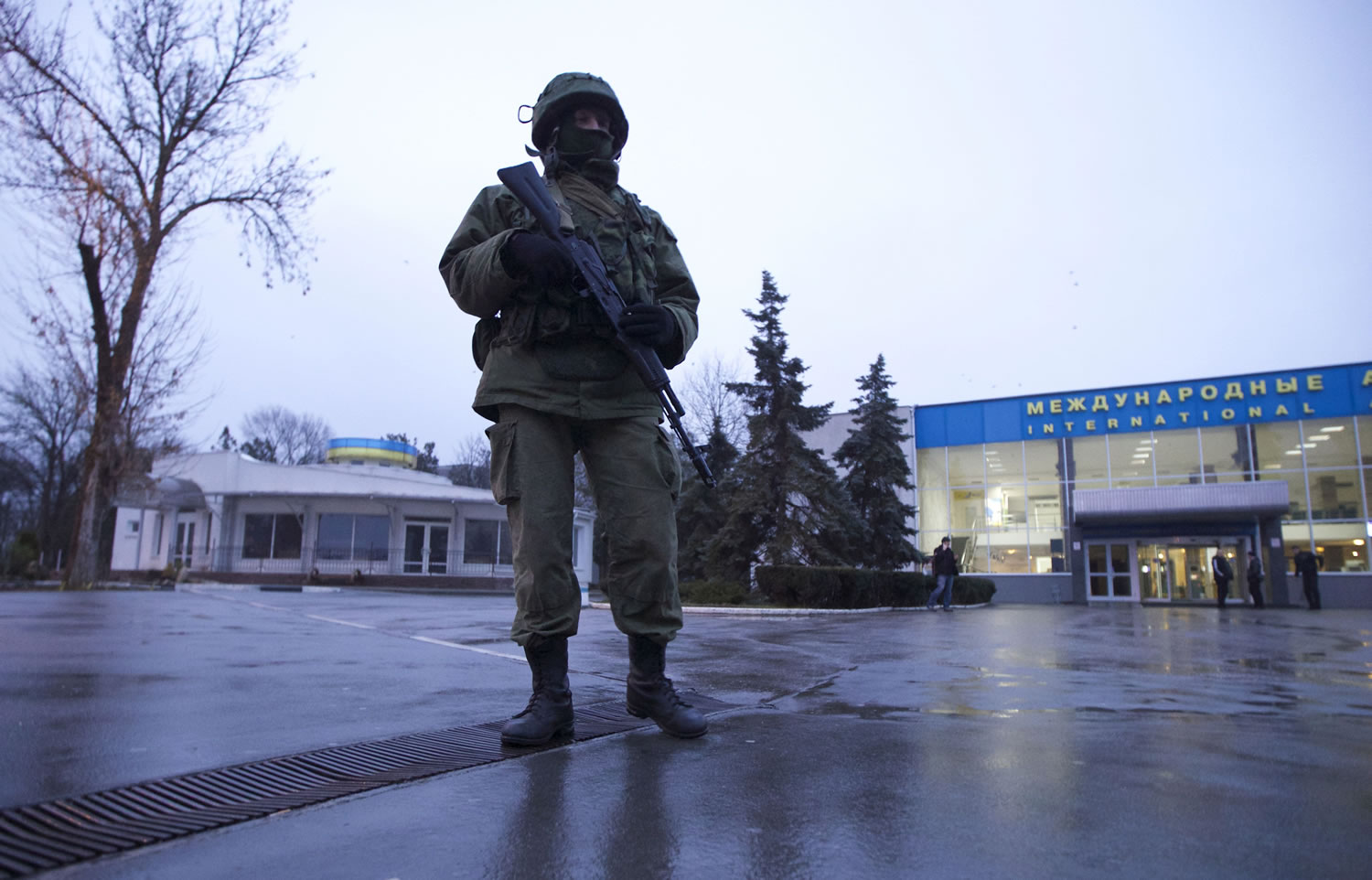 An unidentified armed man patrols a square in front of the airport in Simferopol, Ukraine, on Friday.
