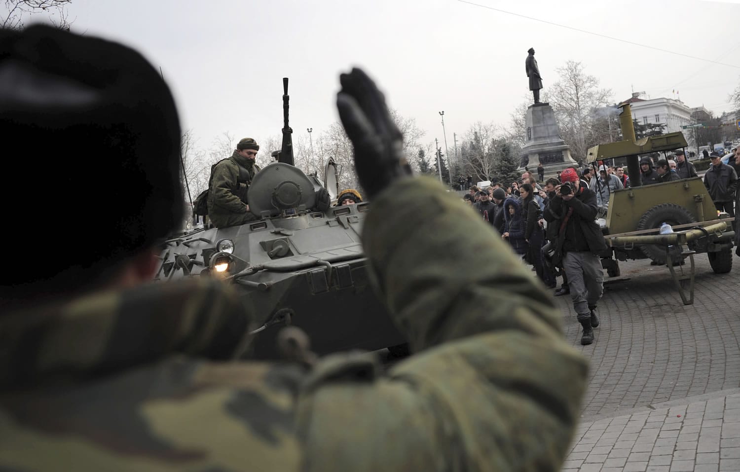 A Russian Army officer, back to camera, helps an armored personnel carrier drive on a street Tuesday in Sevastopol, Ukraine's Black Sea port.