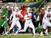 Utah punter Tom Hackett (33) runs the ball after a fake punt during the third quarter Saturday. The run came after a re-kick after the first punt had hit a camera wire hanging over the field.