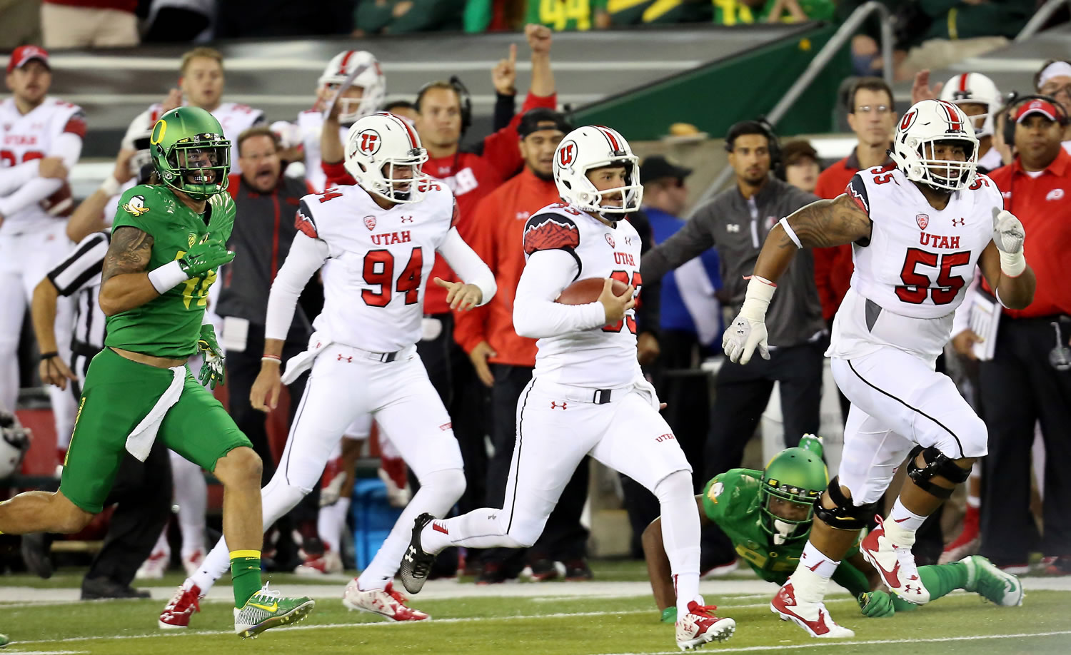 Utah punter Tom Hackett (33) runs the ball after a fake punt during the third quarter Saturday. The run came after a re-kick after the first punt had hit a camera wire hanging over the field.