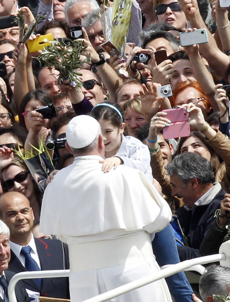 Pope Francis holds a child at the end of the Palm Sunday Mass in St. Peter's Square at the Vatican on Sunday.
