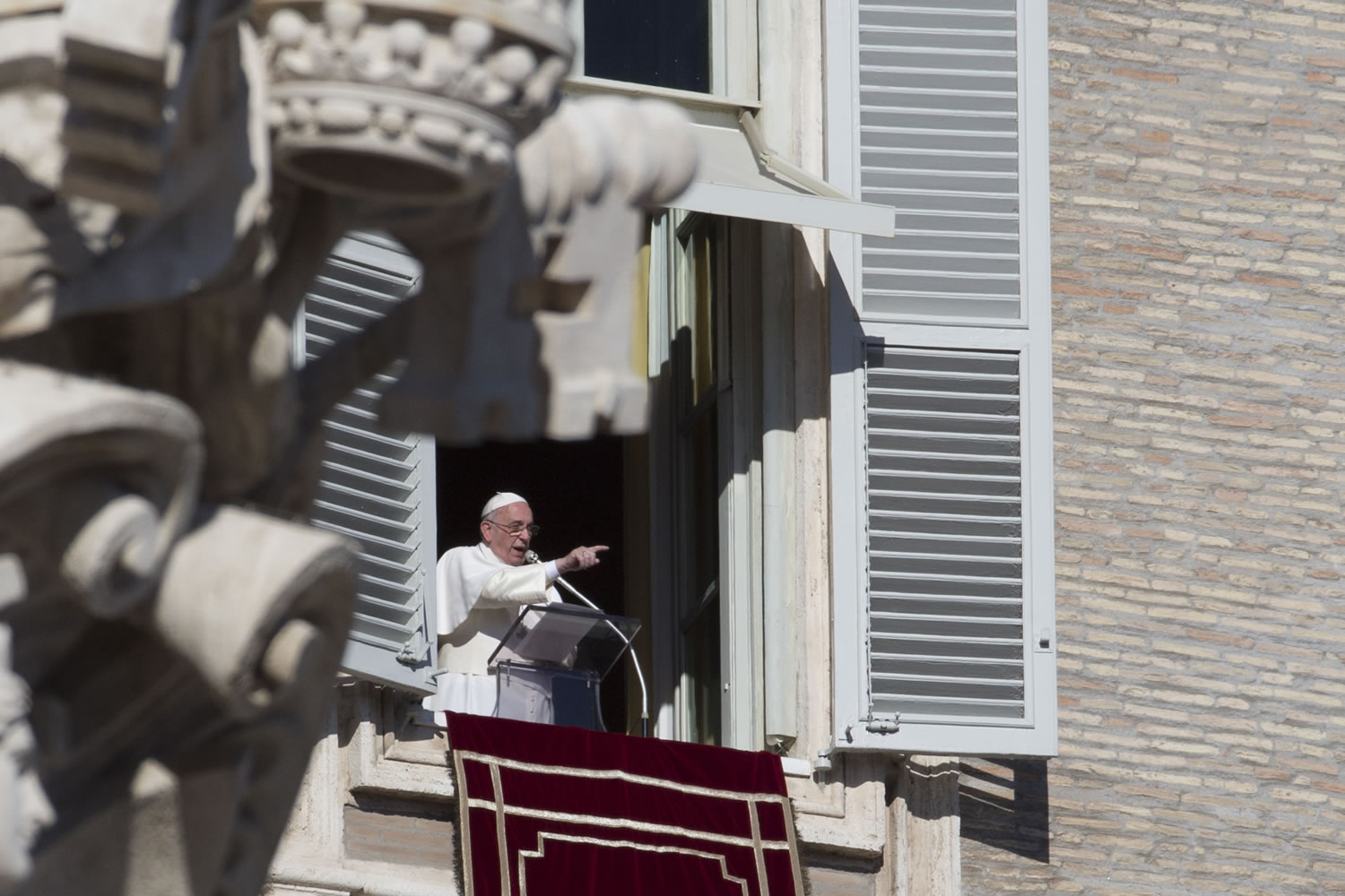 Pope Francis delivers his speech during the Angelus noon prayer he delivered from the window of his studio overlooking St.
