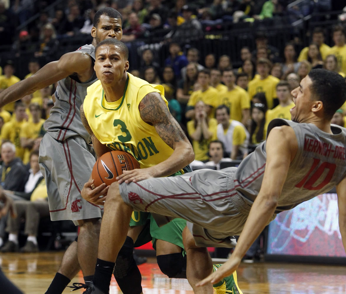 Oregon's Joseph Young (3) is fouled as he drives to the basket between Washington State defenders Royce Woolridge, left, and Dexter Kernich-Drew on Sunday in Eugene.