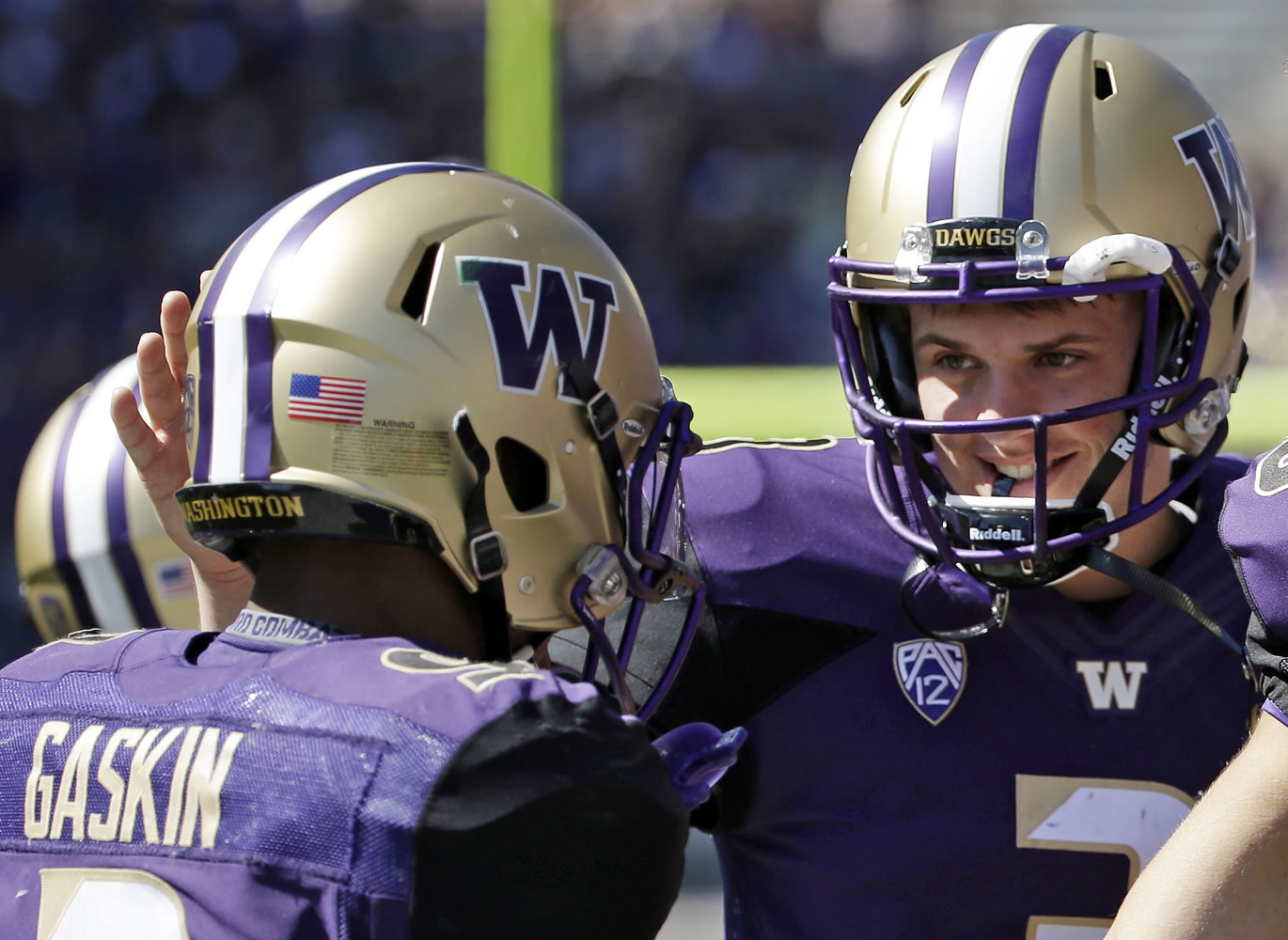 Washington's Myles Gaskin (9) is congratulated on the last of his three touchdowns against Sacramento State by quarterback Jake Browning, right, during the second half in Seattle. Washington won 49-0.