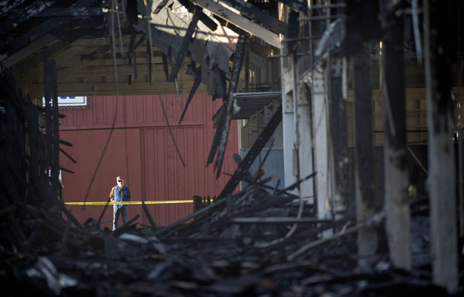 An unidentified man looks at the damage to the Evergreen Hall at the Washington State Fairgrounds in Puyallup on Monday.