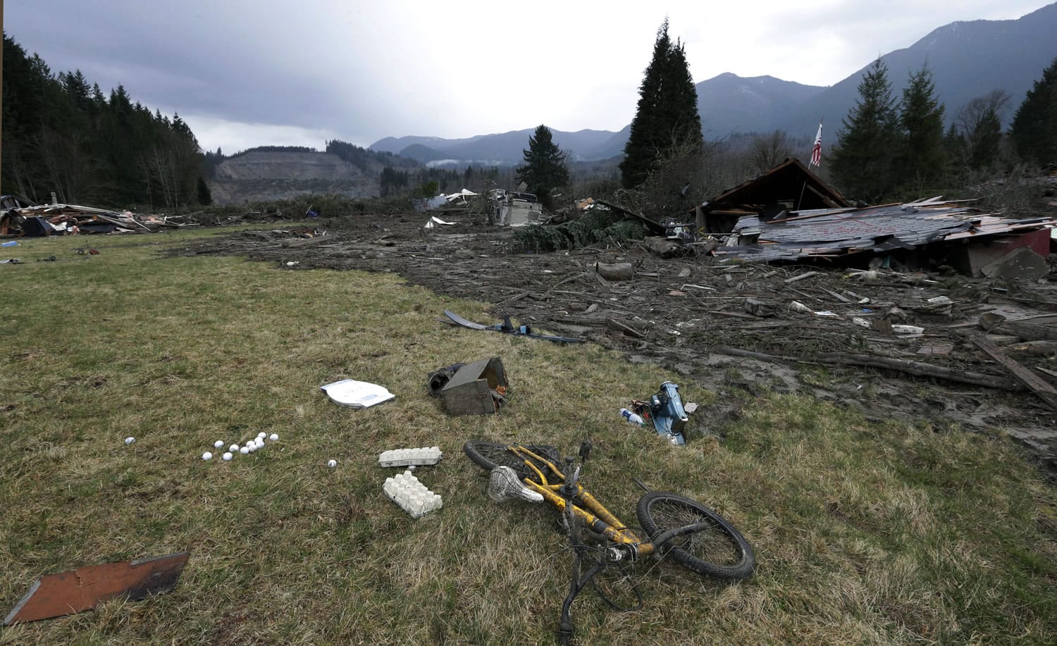 A child's bicycle is with other remains at the edge of the scene of a deadly mudslide from the barren hillside beyond Tuesday in Oso, Wash.