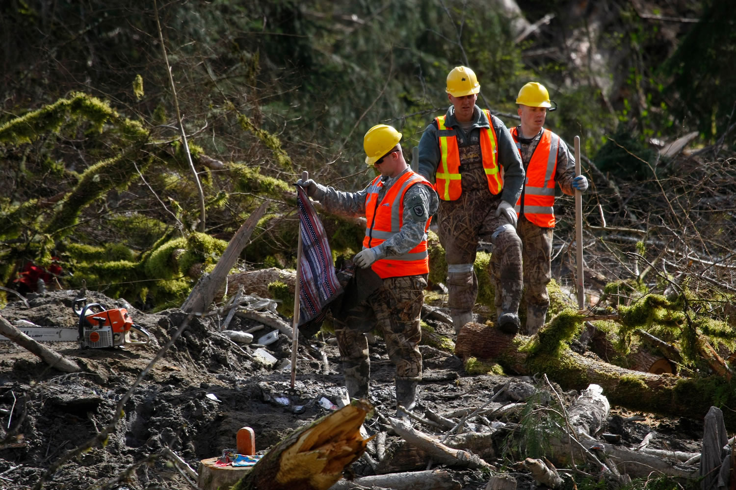 Members of the Washington State National Guard search through debris field for personal items and bodies Wednesday, where workers continued to search through the mudslide area in Oso.