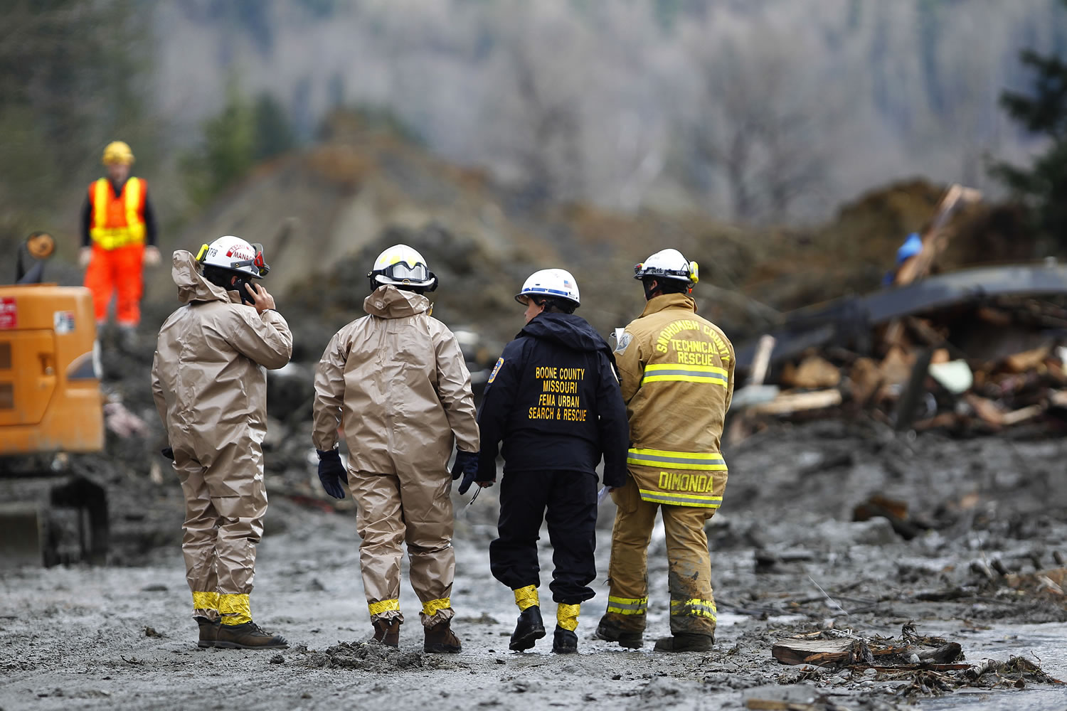 Rescue workers and work crews  toil at the western edge of the mudslide where it covers Highway 530 Wednesday morning east of Oso.