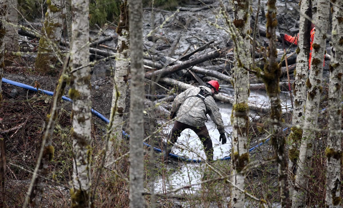 A searcher works at the site of a deadly mudslide Friday in Oso.