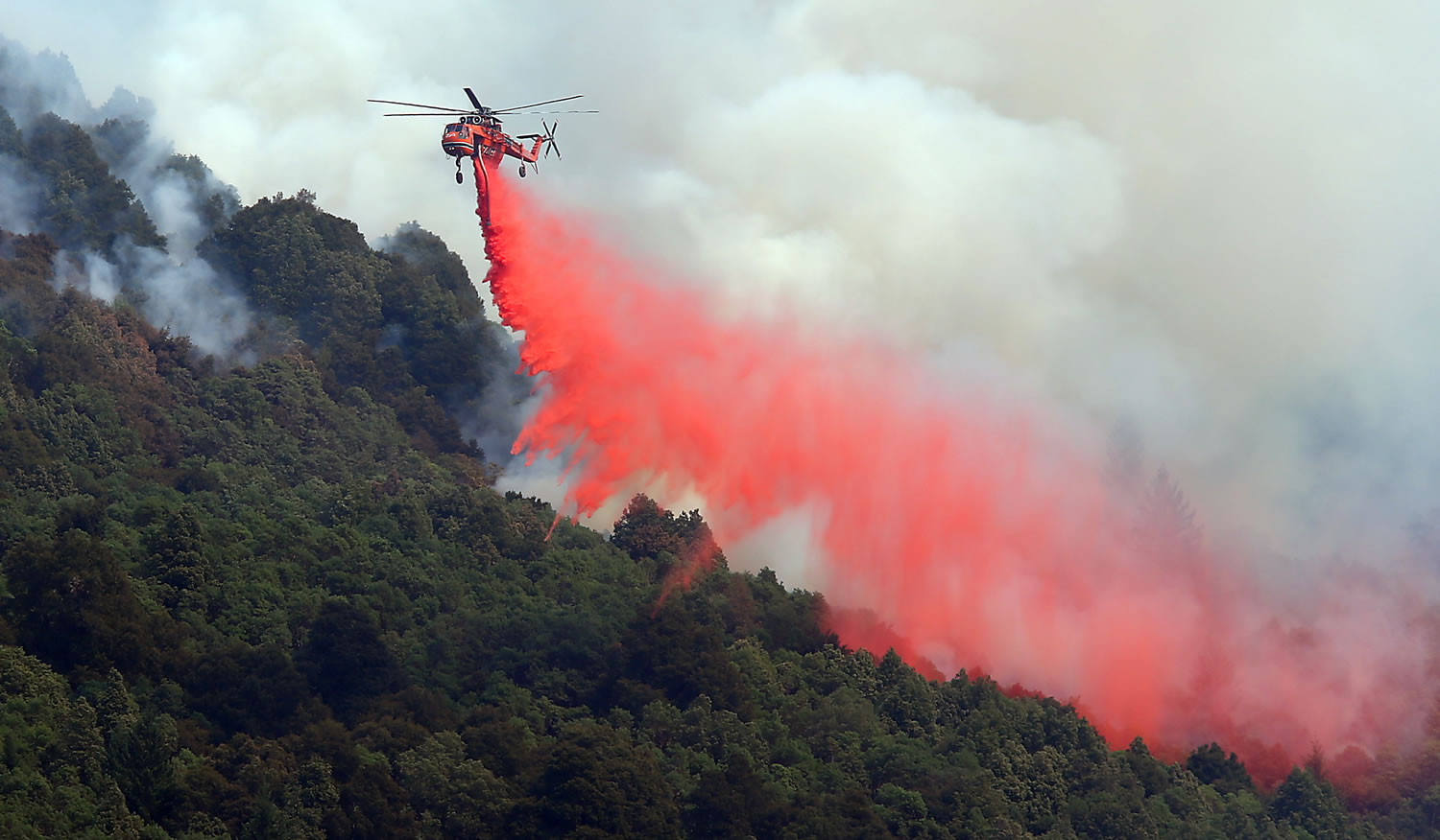 A helicopter drops retardant on an area on the northern end of the Lodge Complex Fire, near Leggett, Calif., on Monday.