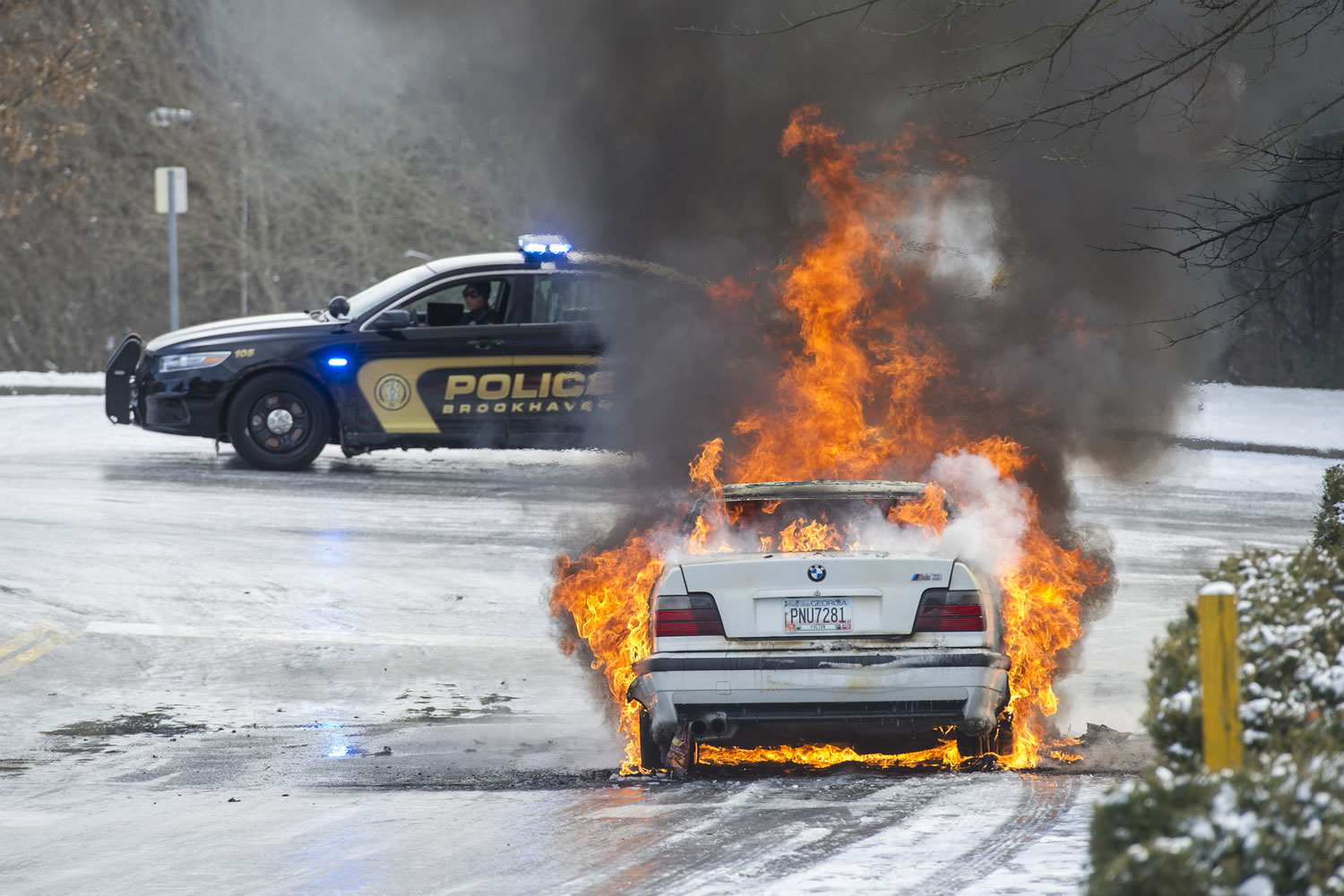 Brookhaven police monitor a car fire in a vehicle left overnight by a motorist who was stranded by impassable roads after winter weather moved through Georgia Wednesday in Brookhaven, Ga.