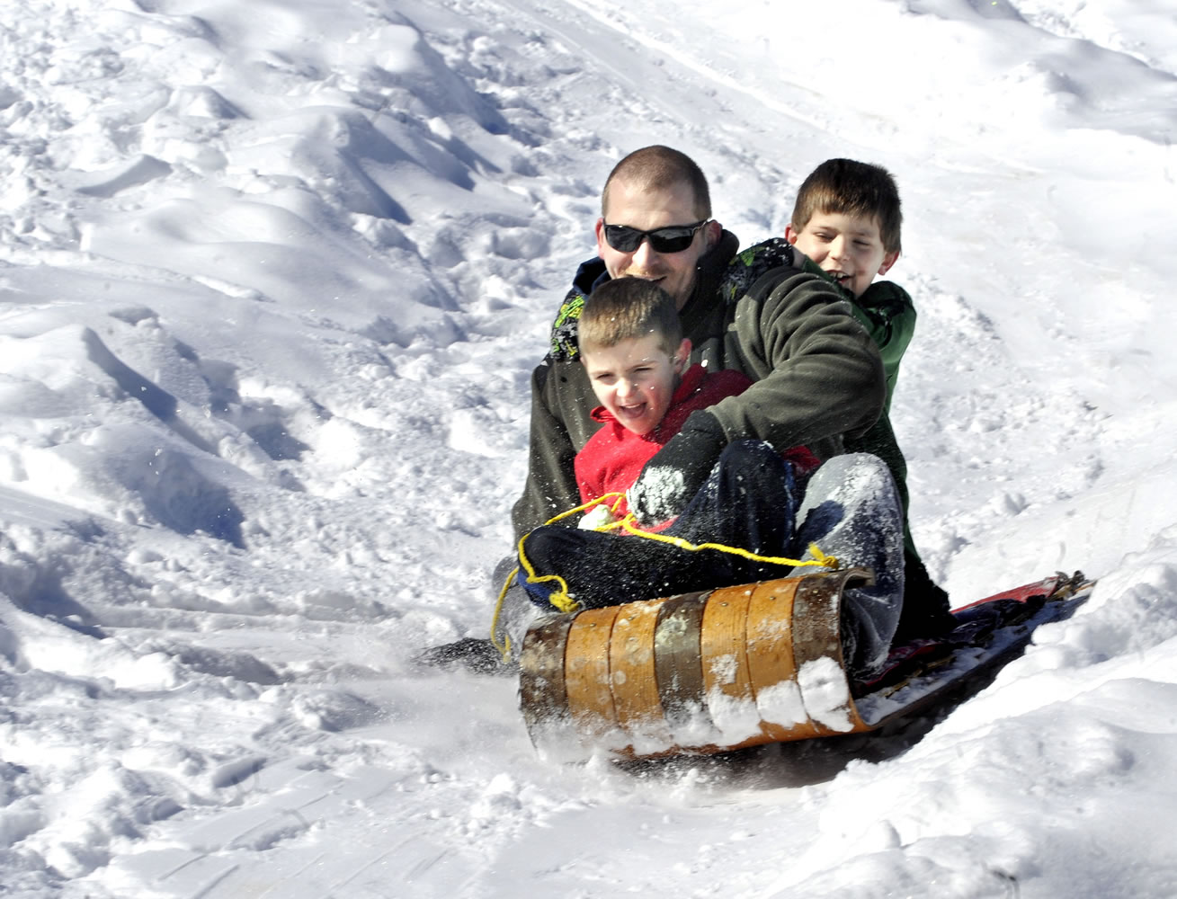 Josh Davis Bloomsburg, Pa., and his sons, Kaden, front, 5, and Cole, 8, ride a toboggan downhill at Joshis cousin Barry J.