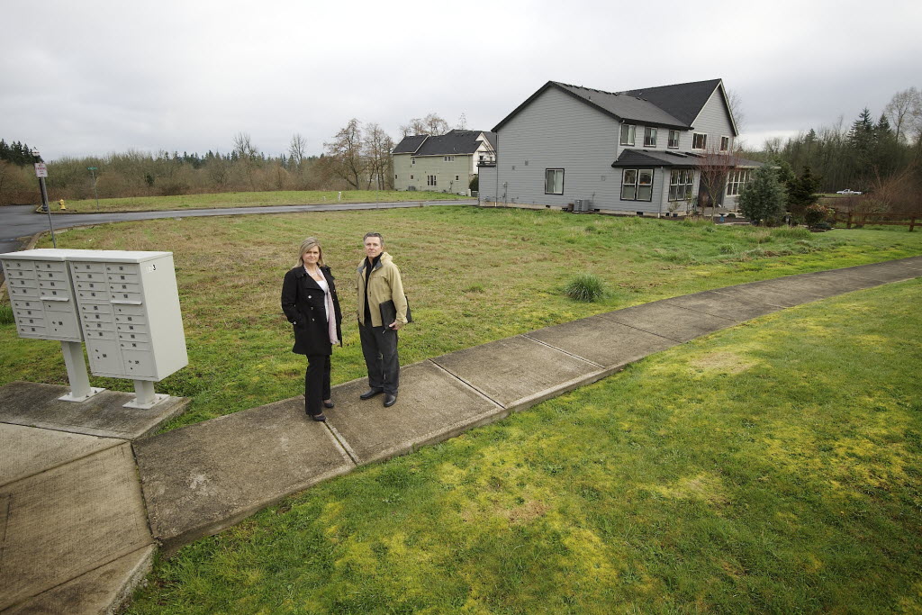 Tracie Jellison, left, and Bernard Stea stand next to undeveloped lots in the Stoneleaf neighborhood where they live in Camas.